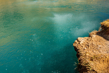 Natural blue spring in Georgia&rsquo;s Truso Valley. Crystal-clear water, visible gas bubbles, and fall tones create a peaceful and surreal geological wonder
