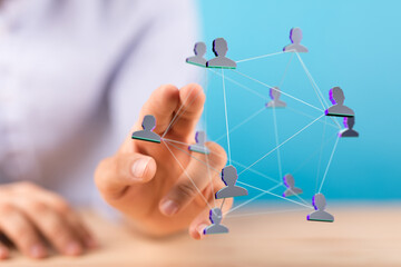 A person reaching out to touch a 3D human network, symbolizing connection, communication, and business across the globe.