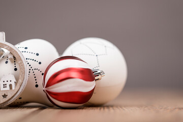 Close-up of Christmas decorations: a red and white striped bauble with other decorative elements and soft background. Perfect for holiday themes