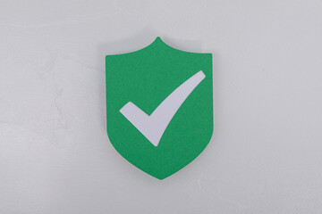 A green shield shape with a white check mark symbol, representing security, approval, and...