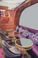 Elegant interior design colorful velvet furnishing bar lounge area onboard cruiseship cruise ship liner in Art Deco Club design with chairs, tables, bar counter and room dividers
