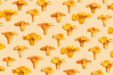 Obraz premium Creative pattern with wild forest chanterelle mushrooms arranged on light beige yellow background. Minimal top view pattern, organic forms, texture of fungus. Autumn healthy food aesthetics concept.