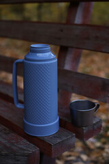 Obraz premium A blue-gray thermos and tin mugs at an autumn picnic