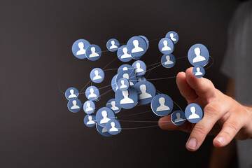 Hand reaching towards a digital network of people connected by lines, representing social...