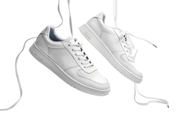 A pair of fresh, clean, crisp white fashion sneakers with untied laces hangs, suspended in air, isolated on a transparent background.