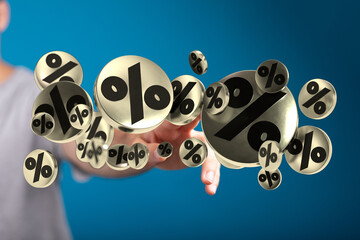Image of a hand reaching out to floating percentage symbols, symbolizing discounts, sales, and...