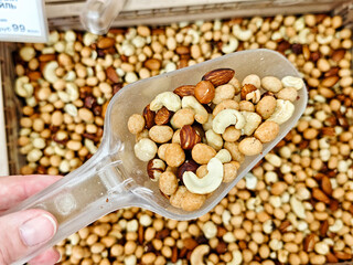 Variety of nuts and seeds displayed in bulk bins at a natural food market in the afternoon sunlight