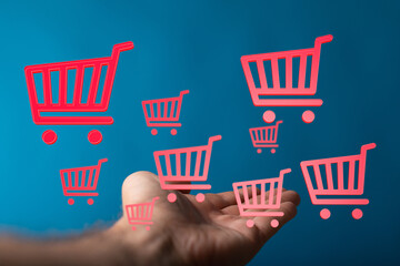 Digitally rendered shopping carts floating above a hand, ideal for illustrating online shopping,...