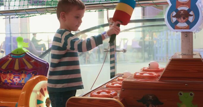 Child Playing Whack-a-Mole Game at Amusement Arcade