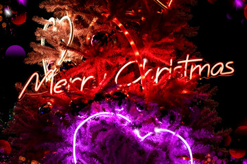 Night Christmas background with neon lights and Merry Christmas inscription, selective focus