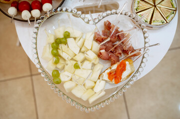 A colorful platter of diced white cheese and grapes, elegantly arranged on a glass platte