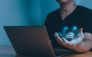 Person using laptop with glowing holographic AI symbol floating above hand, representing artificial intelligence, innovation, and digital technology.