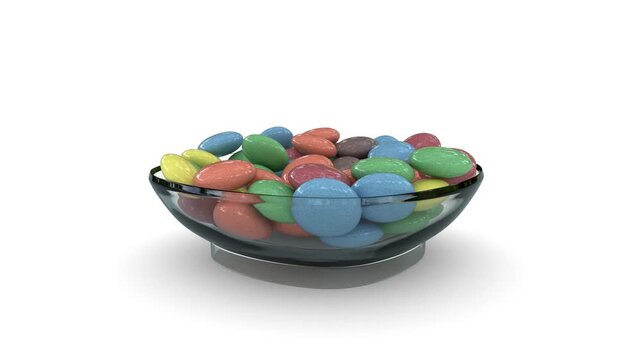 sweet round candy falling into a glass bowl