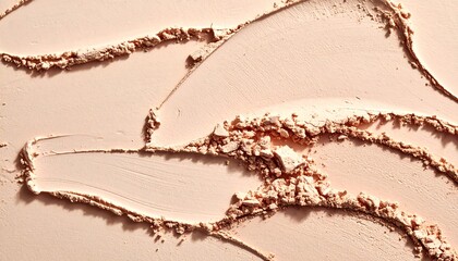 An abstract close-up view displaying the texture of light pink cosmetic powder that has been smoothed onto a surface in brushstrokes
