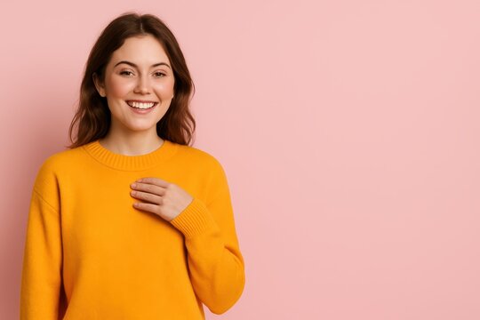 A radiant, sincere woman in a bright yellow sweater smiles warmly at the camera with her hand placed over her heart. This image beautifully conveys trust, gratitude, customer loyalty.