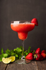 Strawberry margarita in cocktail glass on rustic table. Cocktails and beverages.