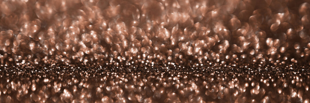 Fototapeta Mocha Mousse, brown sparkling glitter bokeh background banner, abstract defocused texture header. Holiday lights.