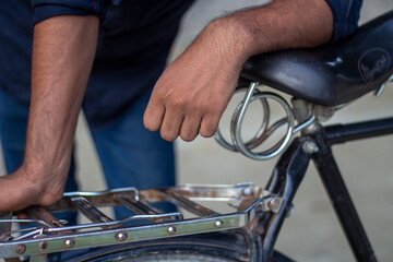 Mans hand resting on the seat of a vintage bicycle