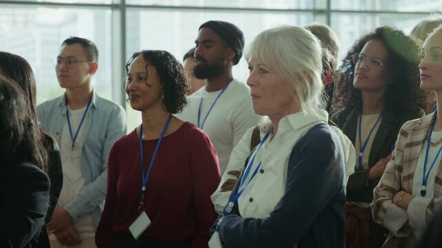 Engaged audience is attentively listening to a speaker at a large conference or business event. These professionals are focused on the presentation, absorbing information in a stimulating environment.