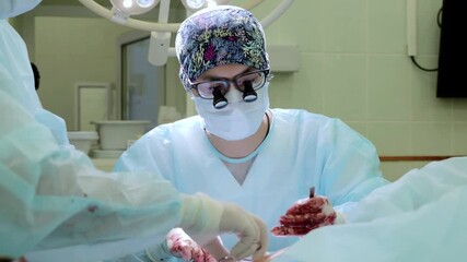 Skilled surgeon wearing surgical mask, magnifying loupes performing intricate medical operation, working alongside colleague in sterile operating environment
