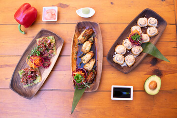 Mesa con muchos platos de sushi y otras comidas asiáticas