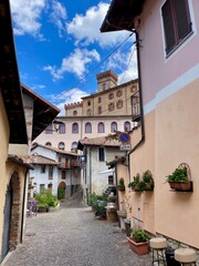 A charming street scene in Barolo, Italy, featuring the historic Castello Falletti di Barolo in the background. Piedmont, Italy.