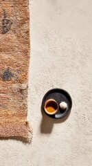 Ceramic cup and round snack on rustic plate next to vintage rug on distressed surface