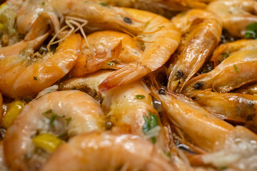 Raw fresh shrimps and langoustines on a frying pan. Close-up of the process of thermal processing of shellfish.