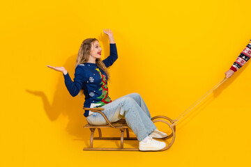 Festive woman enjoying holiday cheer sitting on a sled with a bright yellow backdrop conveying joy and winter celebration