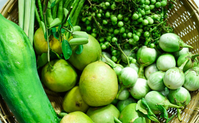 Lemon grass, Lemon Lime, Yard long beans, Mini Eggplant and Papaya in woven basket selling on the street market.