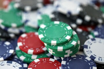 Close up of a group of casino chips on a green mat for poker or dice games indoors