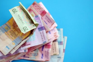 Ukrainian money bills on light blue paper background