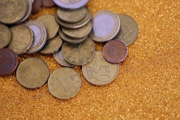 Big amount of euro coins on golden glitter background