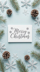 A flat lay arrangement featuring a white card with the text 'Merry Christmas', surrounded by pine cones and snowflakes on a light blue background.