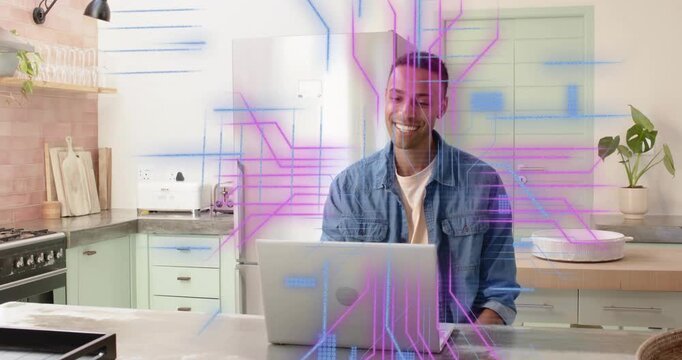 Man sitting on counter smiling at laptop screen starting animated code graphics driving analytics