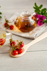 ripe red rose hips for tea on a wooden table