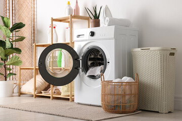 Laundry room interior with washing machine, basket, detergents and houseplants
