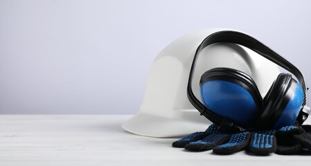 Different safety equipment on white wooden table. Space for text