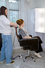 well groomed hair straightening. hair master hands in process of haircuts on background