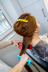 well groomed hair straightening. hair master hands in process of haircuts on background