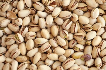Tasty unpeeled pistachios as background, top view flat lay background