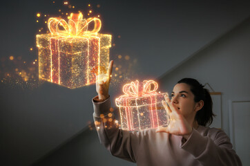 Young woman interacting with holographic Christmas gift boxes indoors
