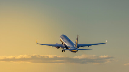 Ryanair airplane taking off into a golden sunset sky, symbolizing travel, freedom, and adventure