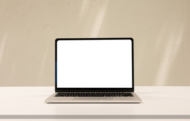 Fototapeta premium close up isolated on blank screen display of laptop computer on table inside beige wall at office room for add content of design banner , website or template or online shopping e-commerce concept