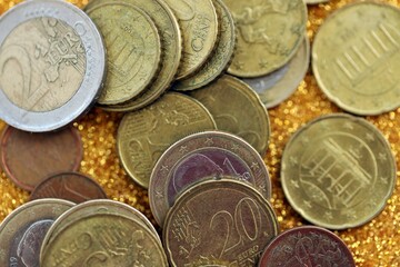 Big amount of euro coins on golden glitter background