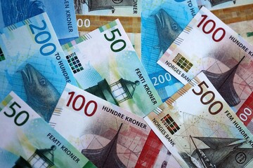 Norwegian Krone currency money bills. NOK currency banknotes in heap with different denomination close up