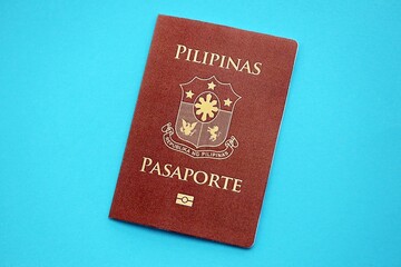 Philippines passport book on light blue paper background close up. Travel document on blue surface