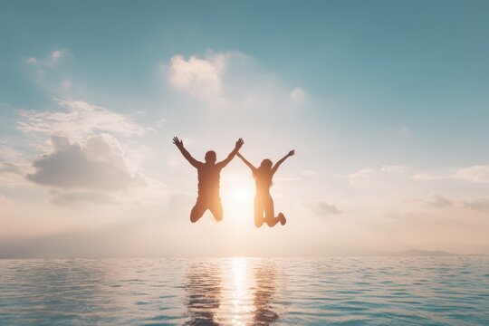 Silhouette of Couple Jumping for Joy at Sunset Over Ocean, Infinity Pool, Backlit, Tropical Vacation, Celebration, Happiness, Travel Destination