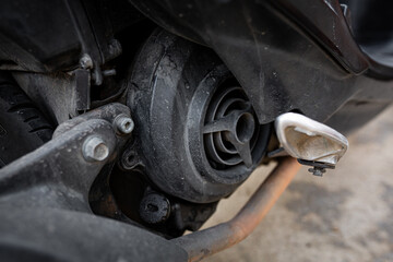 Close-up view of a dusty motorcycle engine and rear wheel area, highlighting the mechanical parts,...