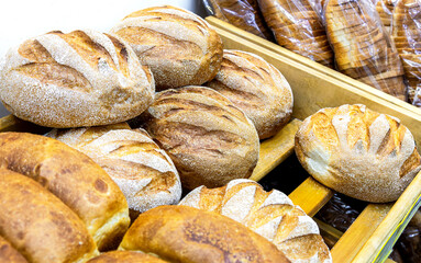 Freshly baked  loaves of bread displayed on wooden shelves in bakery